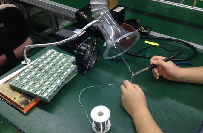 工人使用排烟器进行焊接，确保焊接烟雾安全