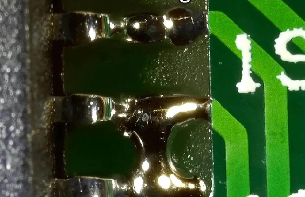 回流焊后 PCB 焊盘上的焊料桥接缺陷。